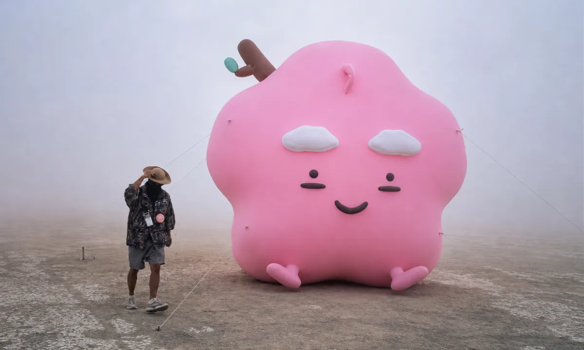 Pink EMO inflatable standing in a dust storm on the playa at Burning Man
