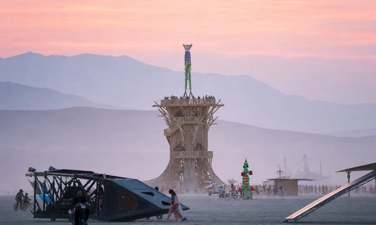 Burning Man art tower installation rising above the dusty playa at dusk