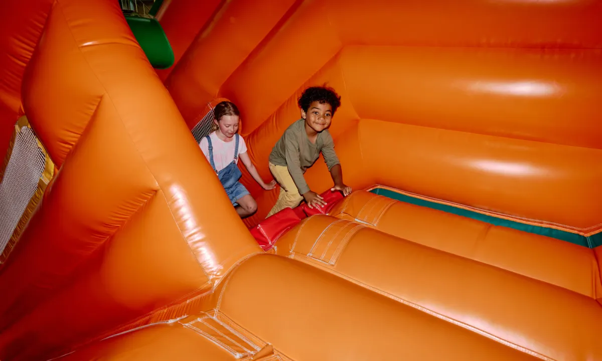Commercial bounce house with slide set up at an outdoor community event