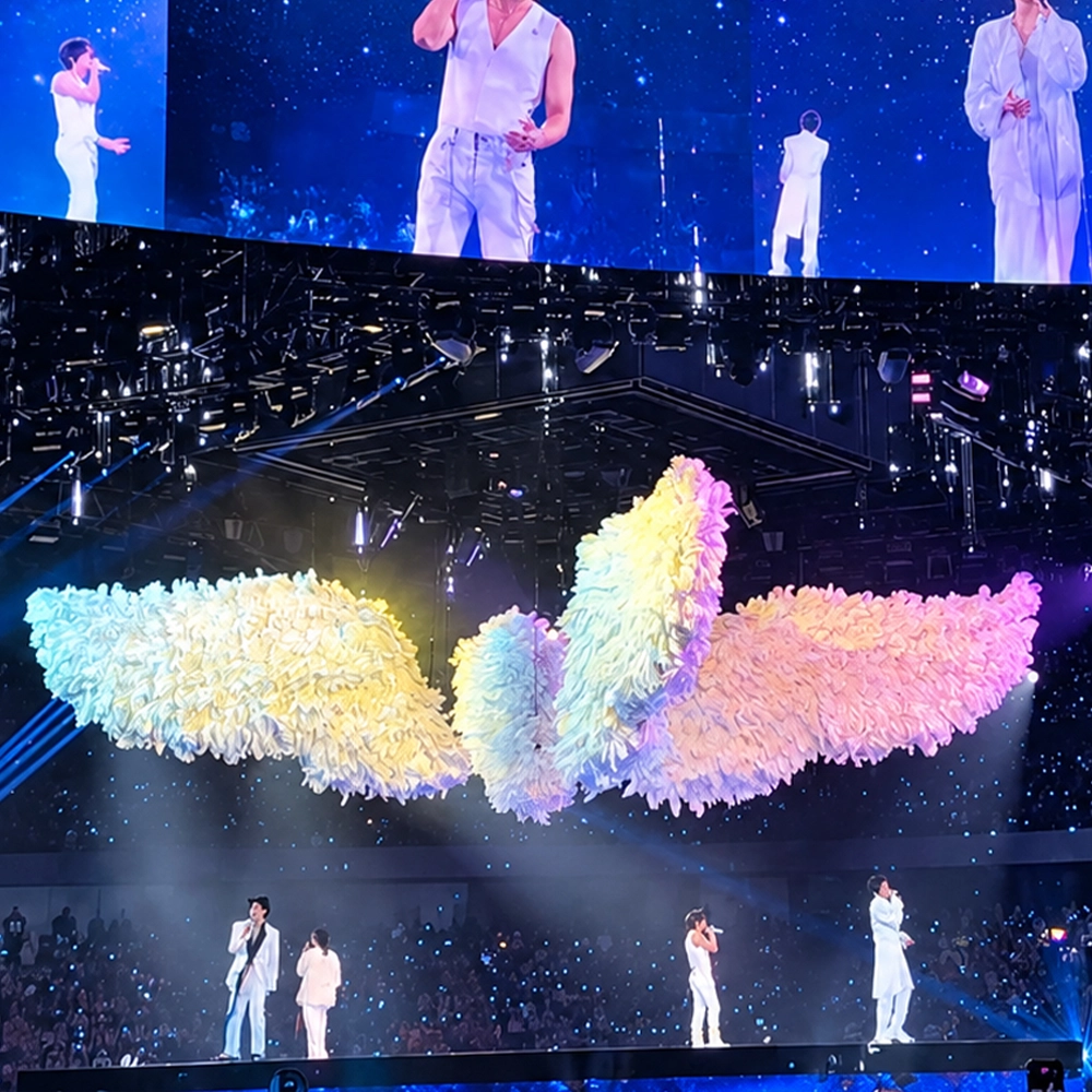 Large white and pink airtight inflatable feather wings custom-made by 360 Inflatable, suspended above the stage at Mayday F4’s City of Stars concert, surrounded by LED screens and stage lighting.